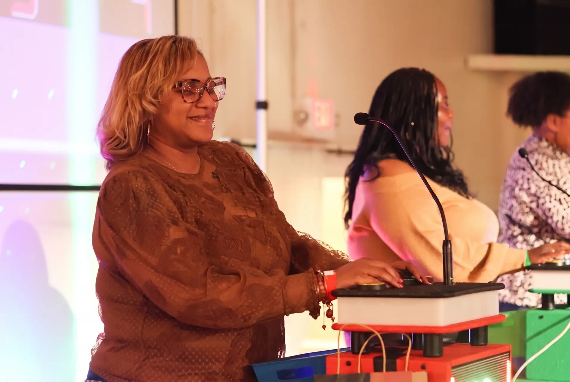 Contestants at lit-up buzzer podiums during a Black In The Day Trivia live show
